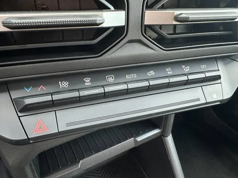 Détail du tableau de bord du Dacia Duster 2025, montrant les commandes de climatisation et les boutons multifonctions.
