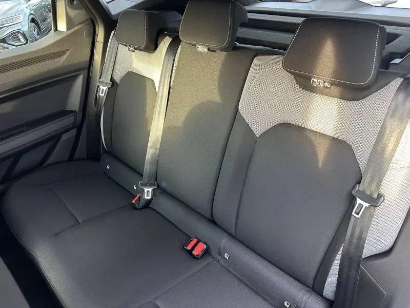 Vue intérieure du siège arrière du Dacia Duster 2025, tissu noir avec appuie-têtes et ceintures visibles.