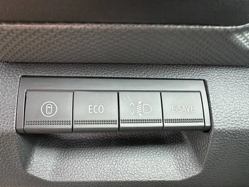 Gros plan sur les boutons de commande noirs du tableau de bord du Dacia Duster 1.8 hybrid 155ch Journey 2025.