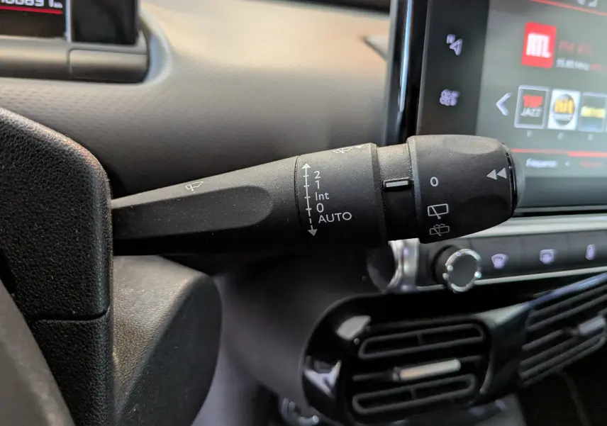 Gros plan sur la commande d'essuie-glace à gauche du volant dans l'habitacle d'une Citroën C4 Cactus blanche 2019.