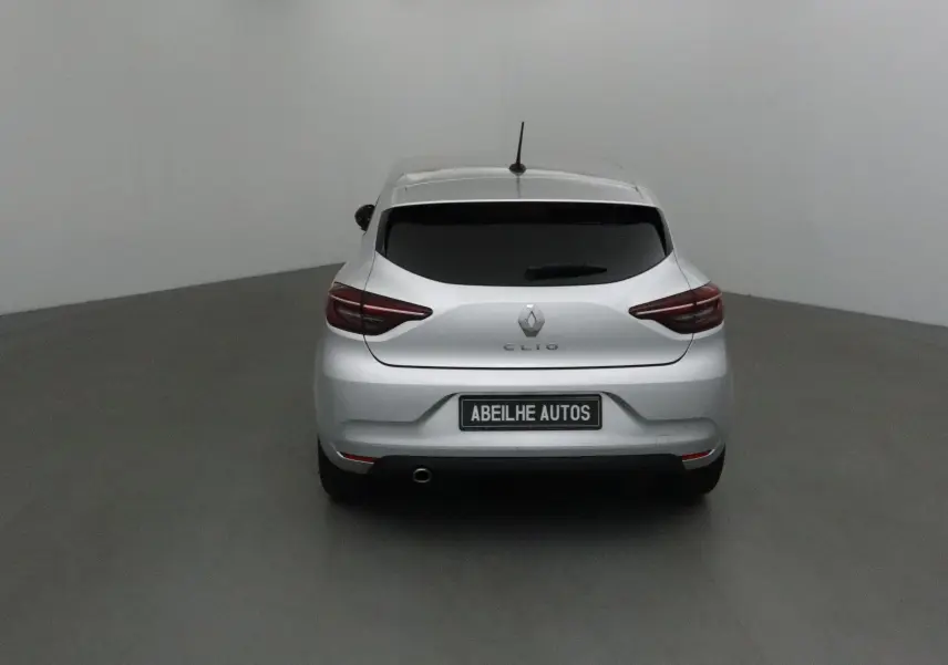 Vue arrière d'une Renault Clio V gris platine 2021 avec vitres teintées et plaque Abeilhe Autos visible.