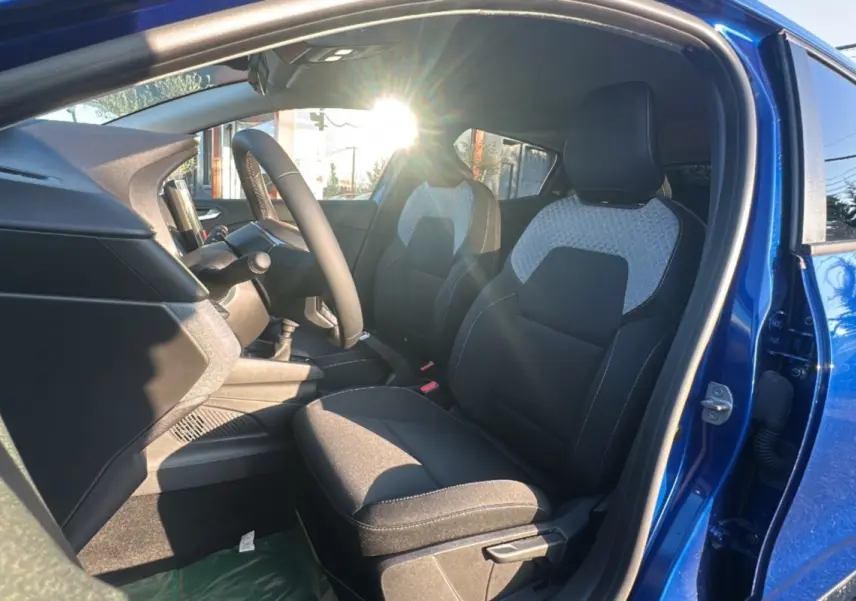 Intérieur avant droit d'une Renault Clio DCI 100 Evolution Camera 2025 bleu iron, sièges tissu noir et gris clair.