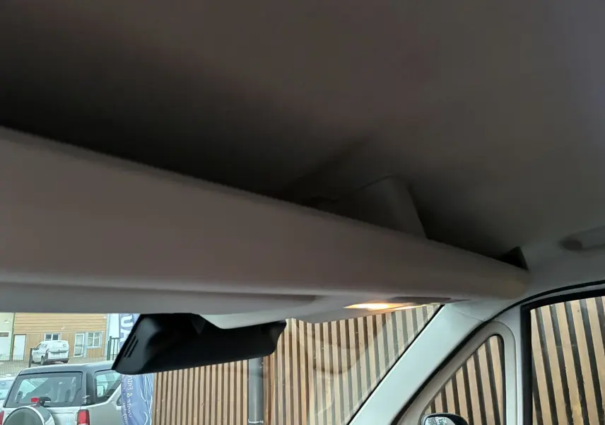 Vue intérieure du pare-soleil et du rétroviseur central du Fiat Ducato Fourgon blanc, avec lumière d’ambiance allumée.