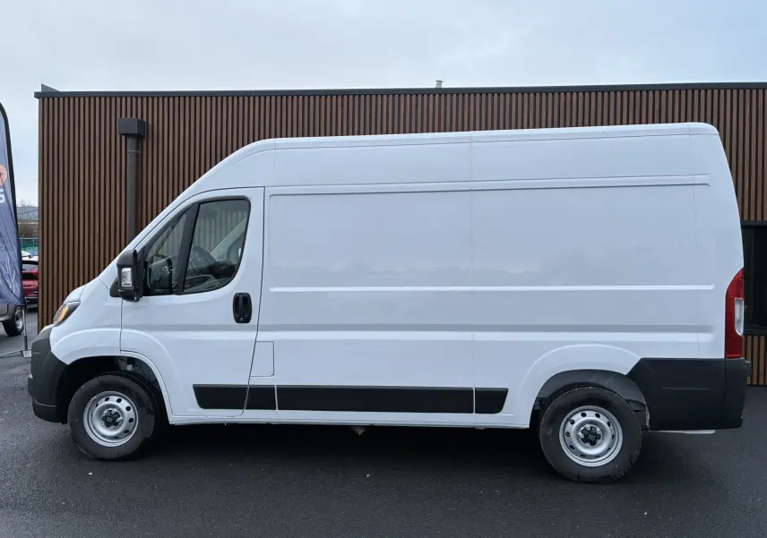 Vue latérale droite d’un FIAT Ducato Fourgon blanc 2025 avec protections noires sur bas de caisse et roues acier.