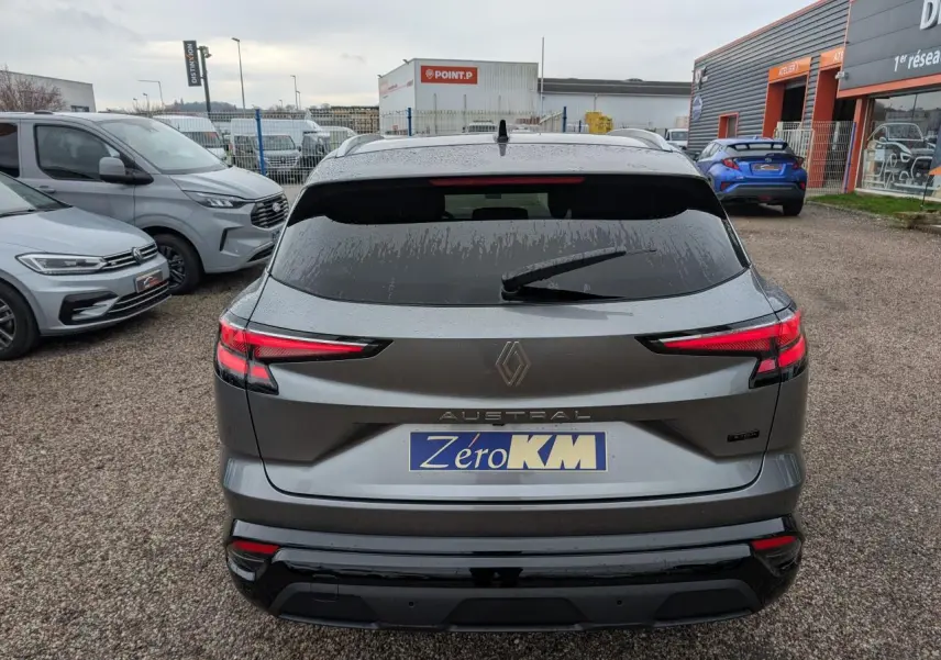 Vue arrière d'un Renault Austral gris avec feux LED étirés et hayon fermé sur un parking extérieur.
