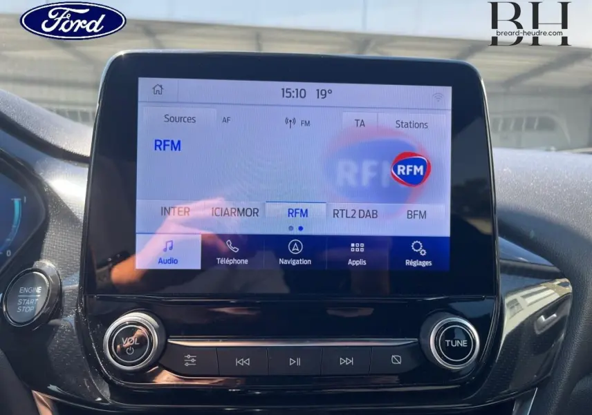 Écran tactile central du Ford Puma 2024 en gros plan, affichant les options radio avec finition noire brillante.