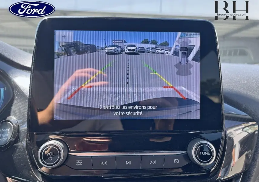 Écran central de la Ford Puma 2024 montrant la caméra de recul avec lignes de guidage colorées, intérieur noir brillant.