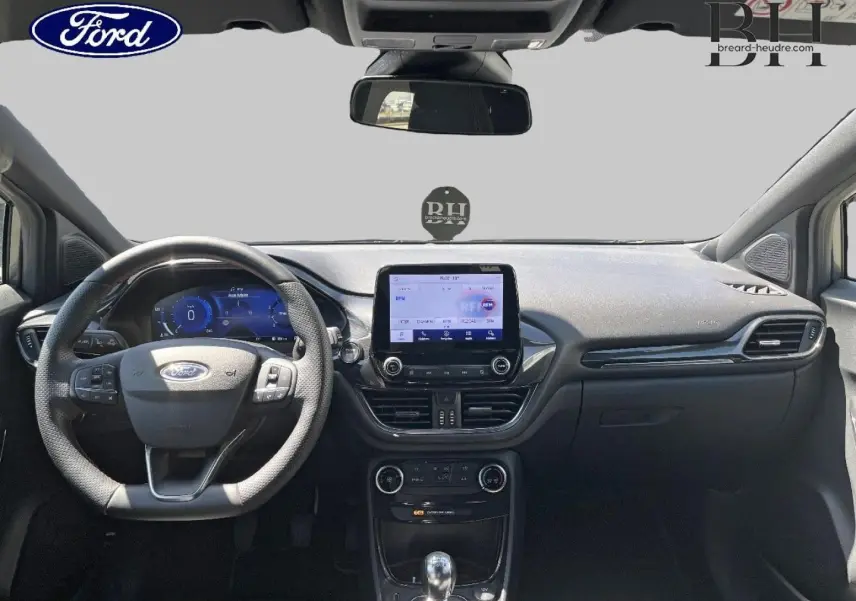 Vue intérieure frontale du tableau de bord et volant du Ford Puma 2024, avec écran tactile et finitions noires.