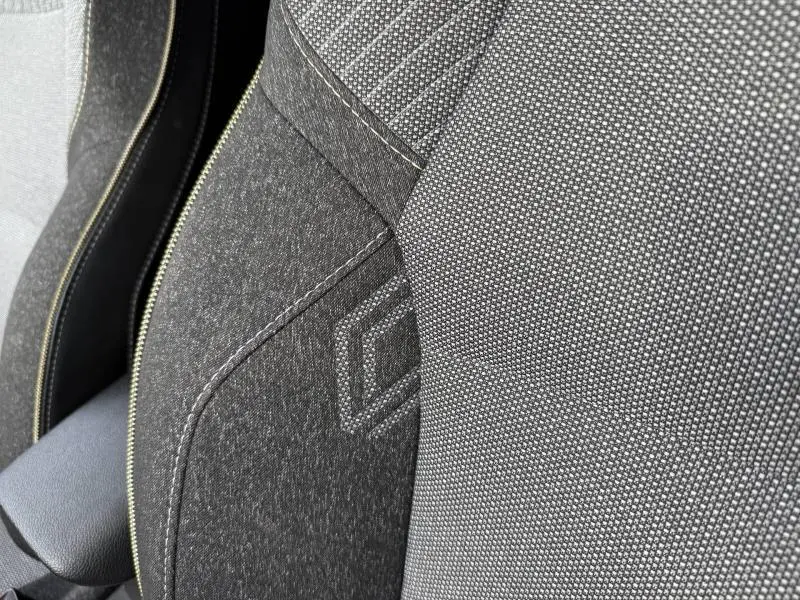 Détail du tissu gris et noir du siège avant du Renault Captur 2025 avec surpiqûres et motif géométrique.