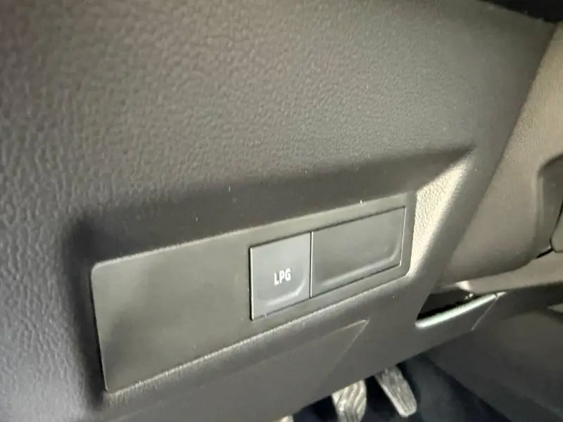 Détail intérieur du tableau de bord du Renault Captur 2025, bouton LPG visible sur plastique noir texturé.