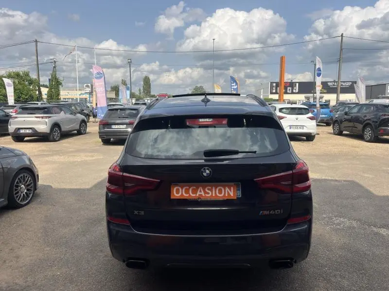Vue arrière d'un BMW X3 M40iA 2019 noir Sophistograu métallisé avec double sortie d'échappement et plaque occasion.