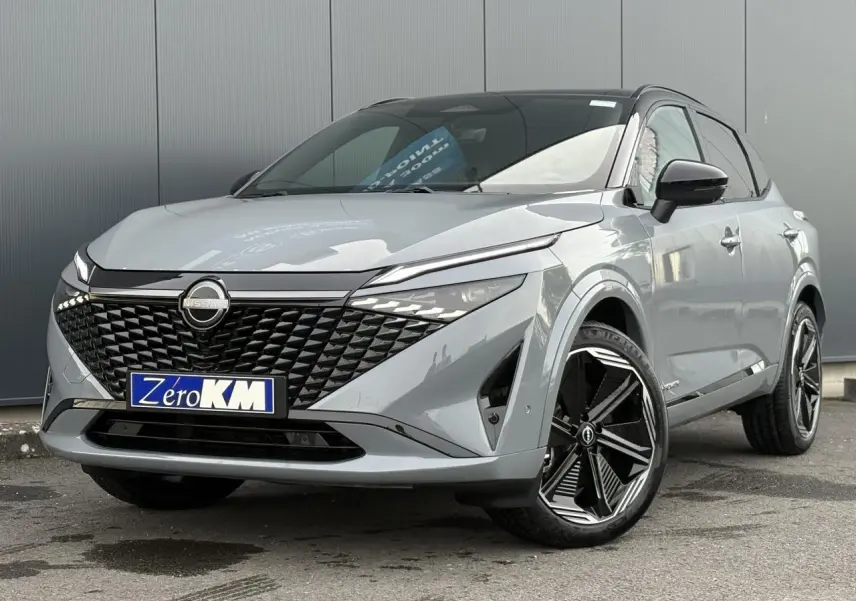 Nissan Qashqai 2025 gris Ceramic en 3/4 avant droit avec toit noir panoramique et jantes alliage 20 pouces.