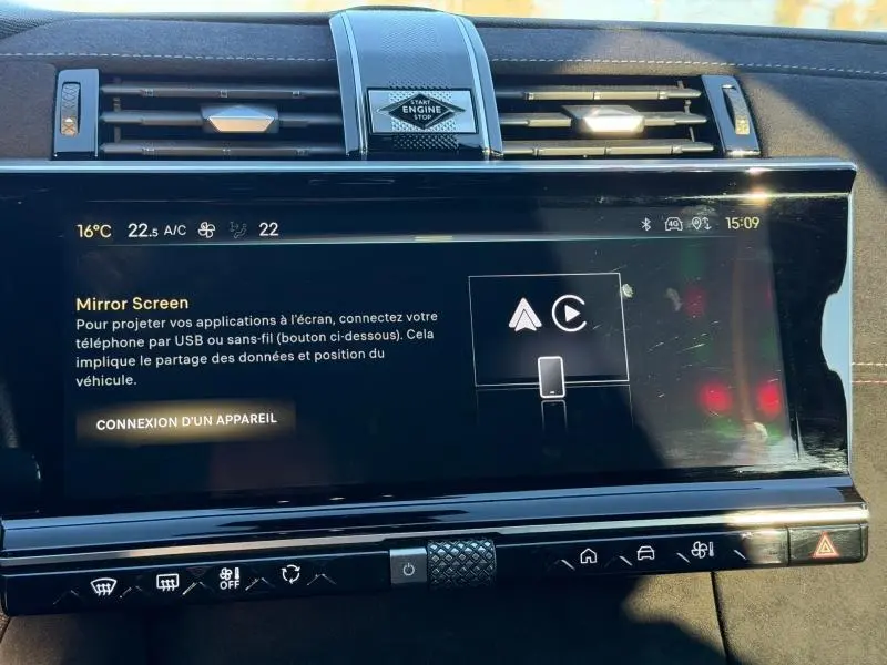 Vue rapprochée de l'écran tactile central et des commandes du tableau de bord du DS7 E-TENSE gris Titane 2024.