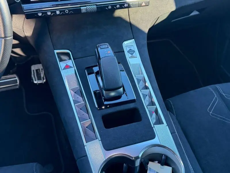 Vue rapprochée de la console centrale du DS7 E-TENSE 225ch gris titane, avec levier de vitesse automatique et commandes tactiles.