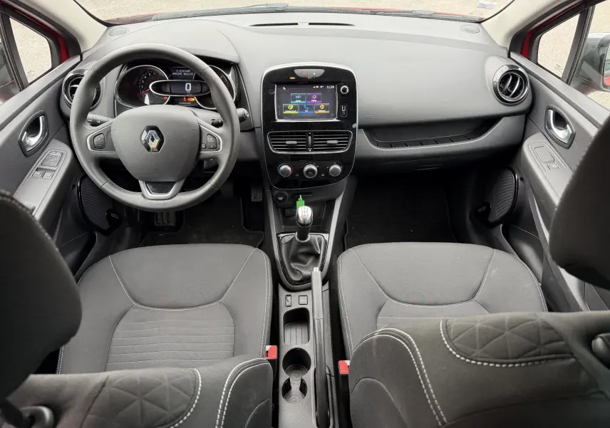 Vue intérieure avant de la Renault Clio IV Limited TCe 90, tableau de bord avec écran tactile et volant multifonction noir.