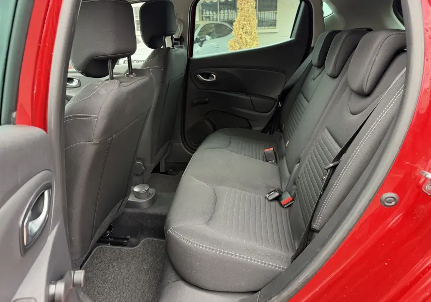 Vue intérieure arrière côté droit de la Renault Clio IV Limited rouge flamme, montrant les sièges arrière en tissu noir.