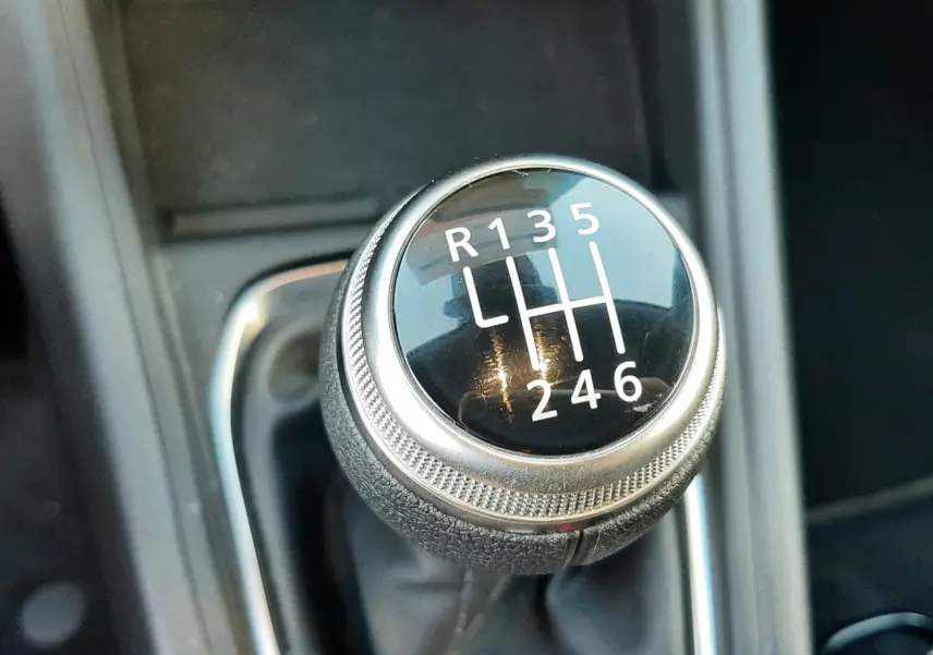 Gros plan sur le levier de vitesse manuel noir et chrome du Renault Captur 2024, montrant les six rapports et la marche arrière.