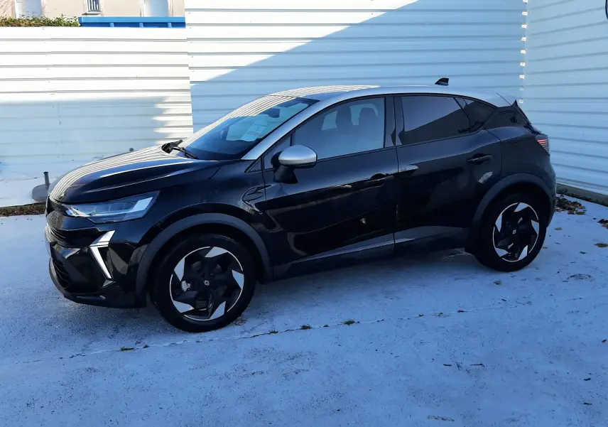 Renault Captur 2024 noir métal avec toit gris, vue de profil côté gauche, jantes noires et design moderne.