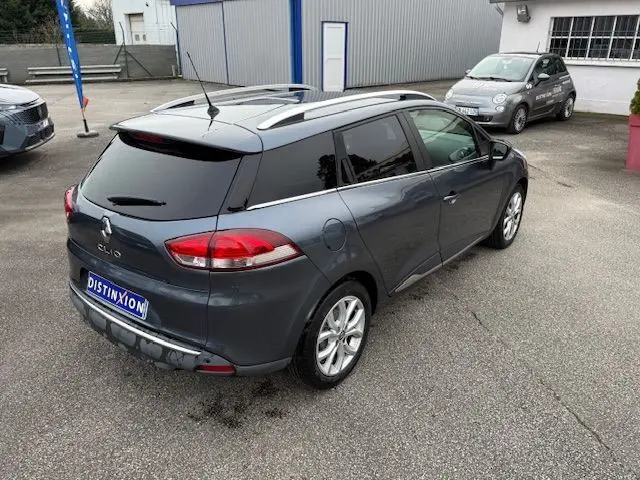 Vue 3/4 arrière droite d'une Renault Clio IV Estate gris titanium métallisé avec toit noir et jantes alliage 16 pouces.