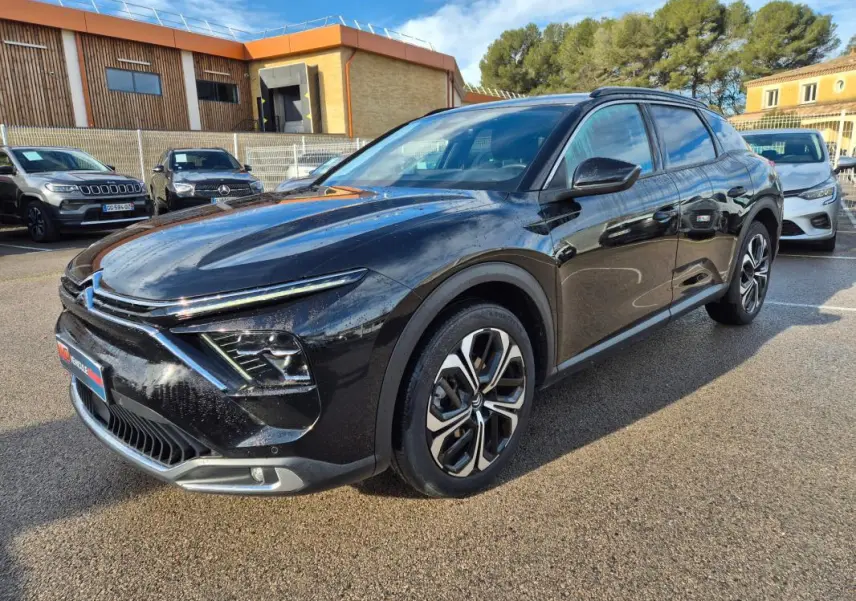 Vue 3/4 avant droite d'une Citroën C5 X noire 2024 avec jantes alliage 19 pouces et phares LED distinctifs.