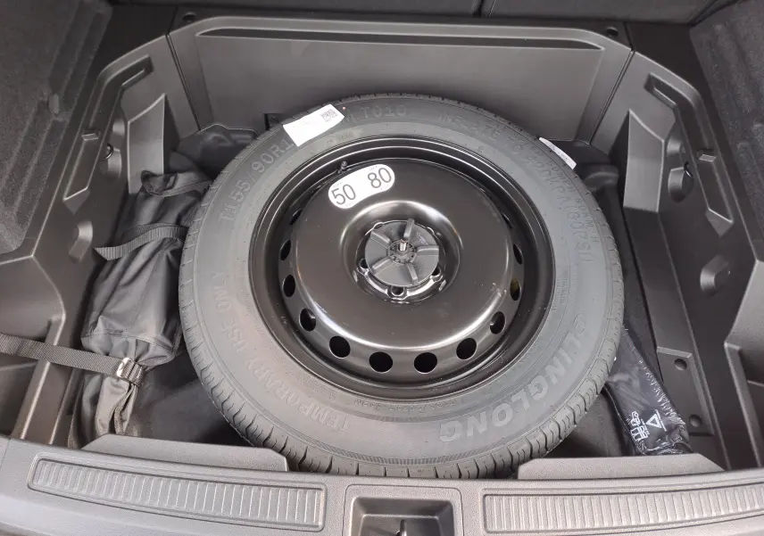 Vue rapprochée de la roue de secours noire dans le coffre du Renault Austral gris schiste 2025 hybride.