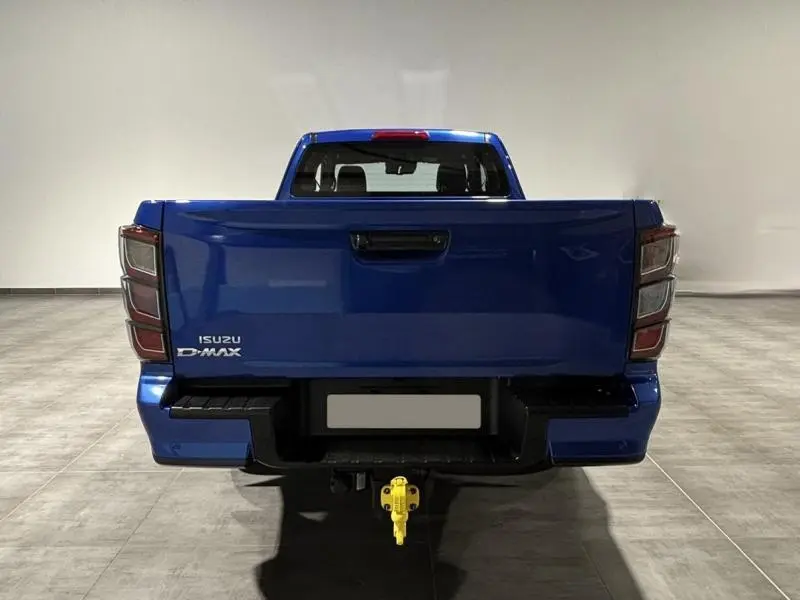 Vue arrière d'un pick-up Isuzu D-MAX 2025 en bleu Biarritz avec attelage de remorque jaune visible.