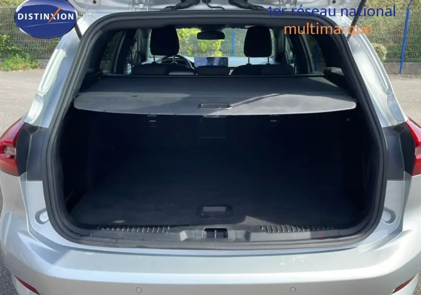Vue arrière du coffre ouvert d'une Ford Focus SW 2023 gris lunaire métal, montrant l'espace de chargement vide.