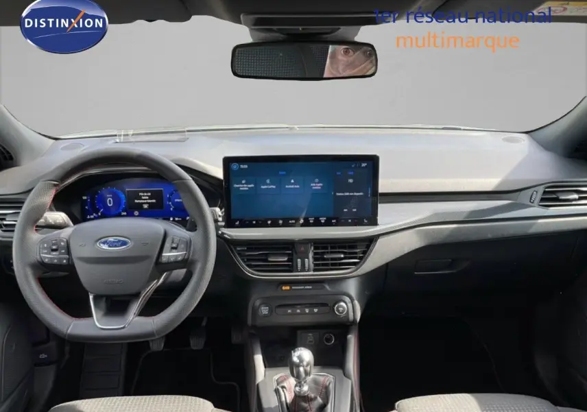 Vue intérieure avant de la Ford Focus SW gris lunaire, tableau de bord moderne avec écran tactile large et volant multifonction.