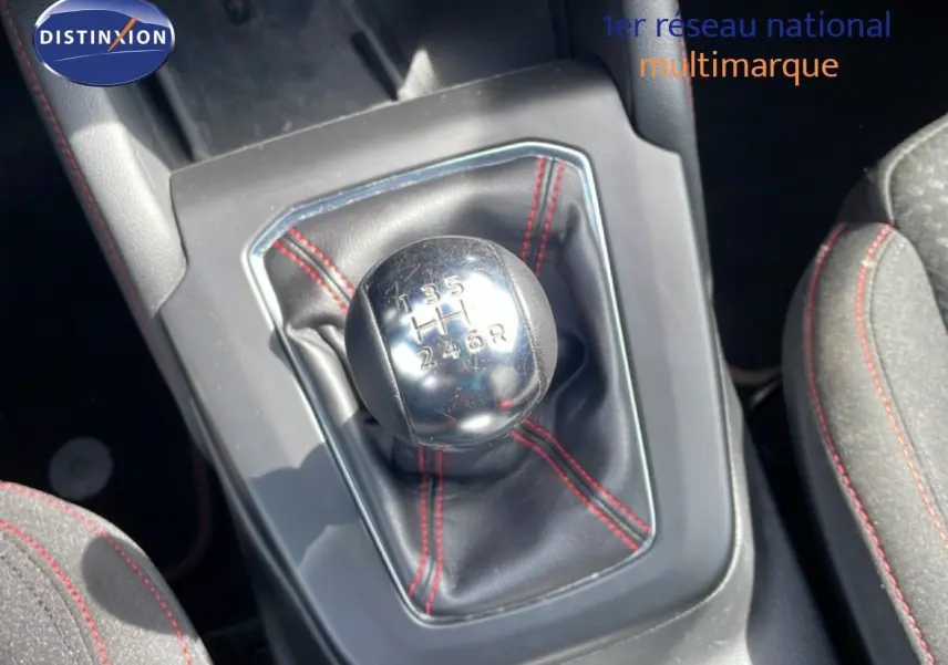 Gros plan sur le levier de vitesses manuel avec soufflet noir et surpiqûres rouges dans une Ford Focus SW gris lunaire 2023.