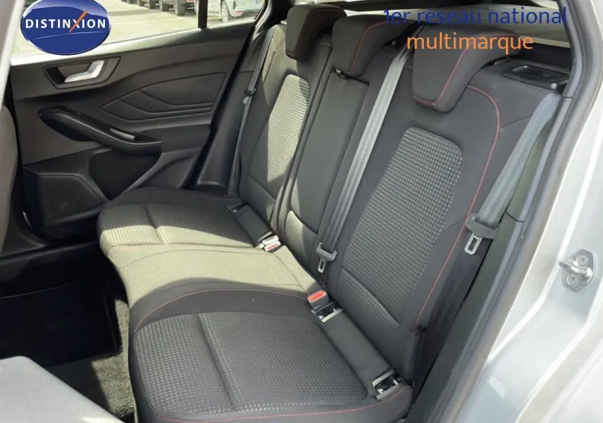 Vue intérieure côté droit des sièges arrière noirs avec surpiqûres rouges d'une Ford Focus SW gris lunaire 2023.
