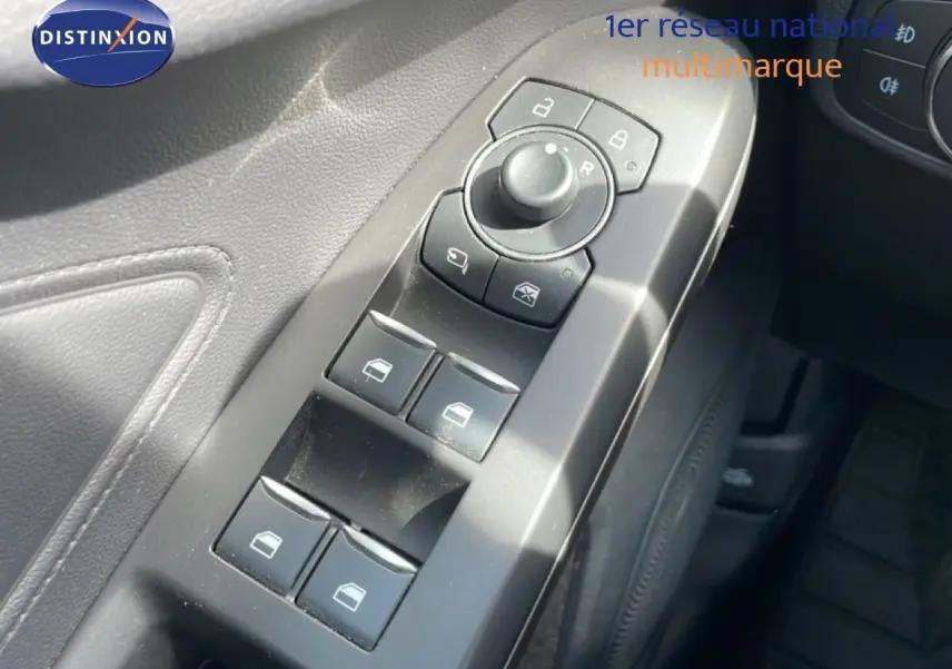 Gros plan sur les commandes de lève-vitres et rétroviseurs côté conducteur de la Ford Focus SW 2023, intérieur noir.
