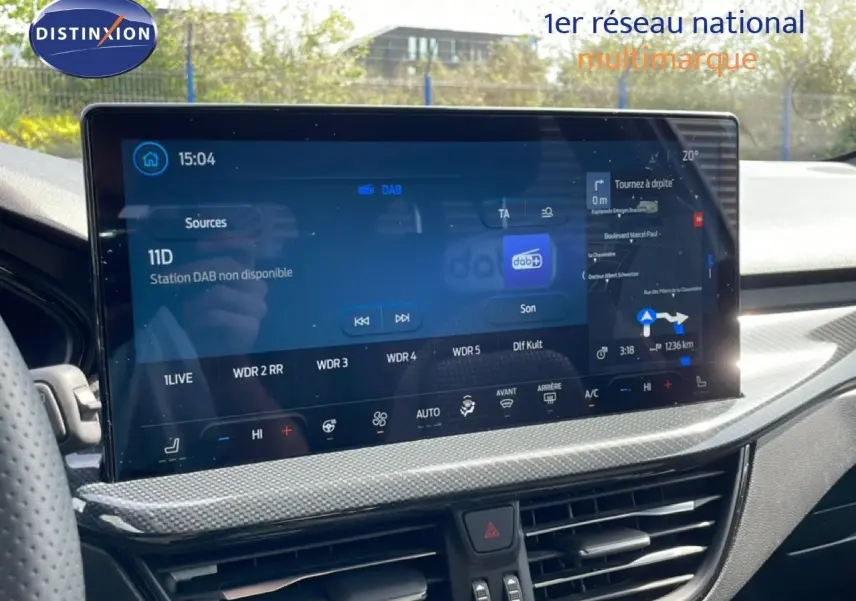Vue intérieure du tableau de bord de la Ford Focus SW 2023, écran tactile large avec navigation et climatisation.