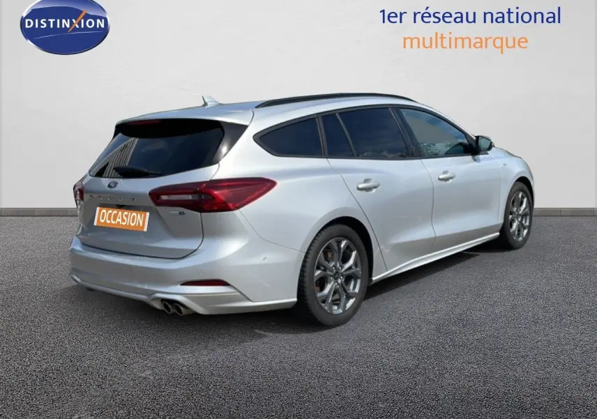 Vue 3/4 arrière droite d'une Ford Focus SW gris lunaire métal avec jantes alliage et vitres teintées.