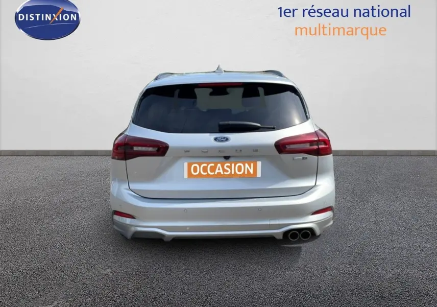 Vue arrière d'une Ford Focus SW gris lunaire métal 2023 avec double sortie d'échappement et vitres teintées.