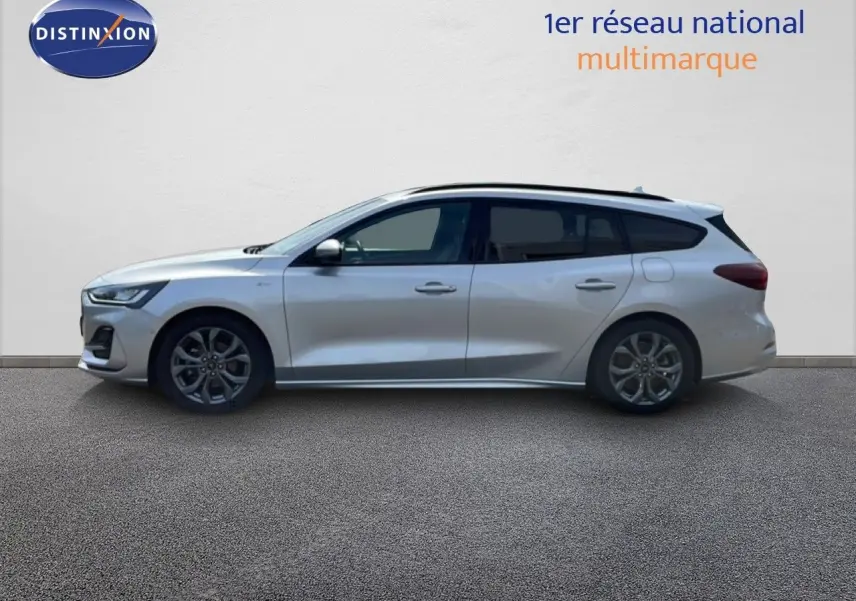 Profil côté gauche d'une Ford Focus SW 2023 gris lunaire métal avec jantes alliage et toit ouvrant.