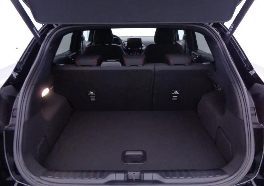Coffre ouvert en vue arrière d'une Ford Puma noir agate métal, montrant l'espace de chargement et les sièges arrière.