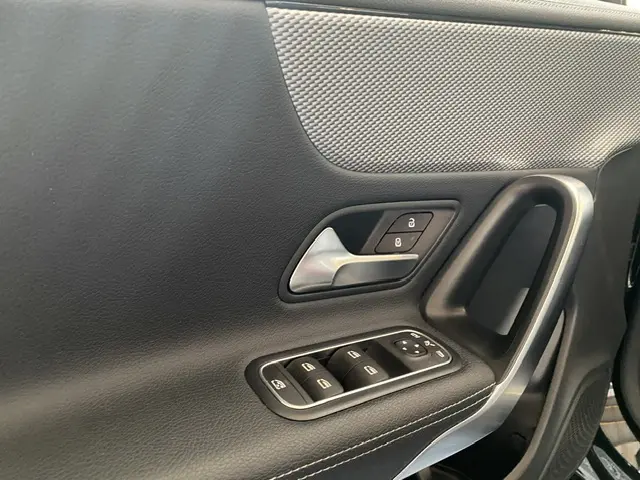 Gros plan sur la porte intérieure côté conducteur noire du Mercedes CLA 200 d 2021 avec commandes de vitres et verrouillage.