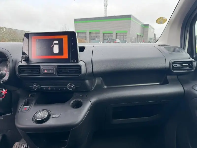 Tableau de bord noir du Citroën Berlingo Fourgon 2020 avec écran tactile central et commandes circulaires visibles de face.