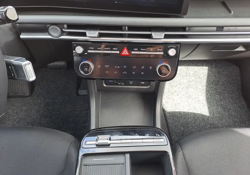 Vue rapprochée du tableau de bord et console centrale du Hyundai Tucson 2025, intérieur noir avec commandes digitales.