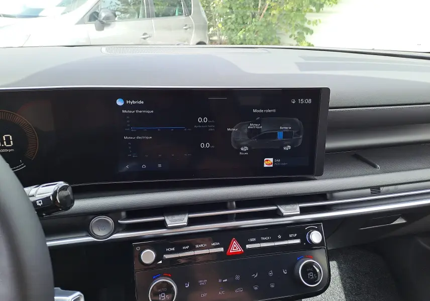 Tableau de bord du Hyundai Tucson 2025 hybride, affichage digital central avec infos moteur thermique et électrique, intérieur noir.