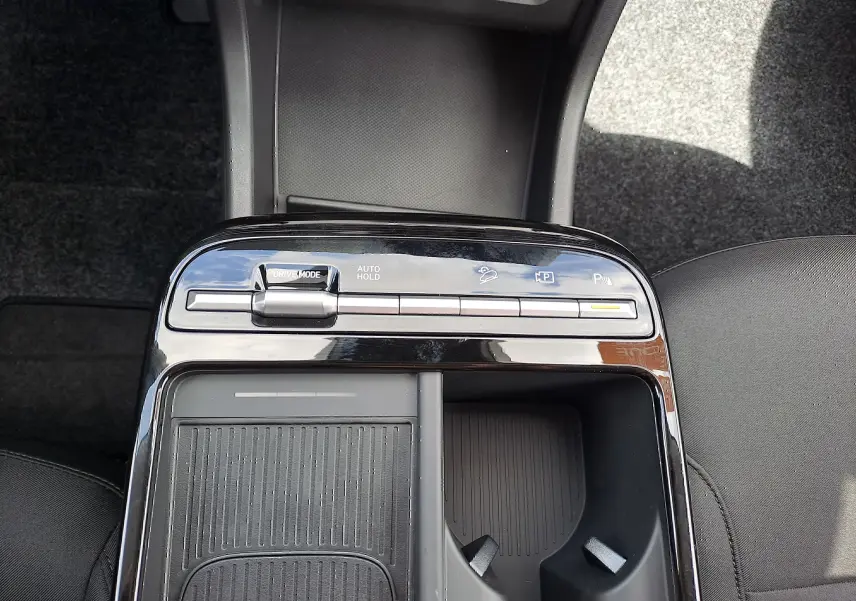 Gros plan sur la console centrale noire du Hyundai Tucson 2025 avec commandes de mode de conduite et porte-gobelets.