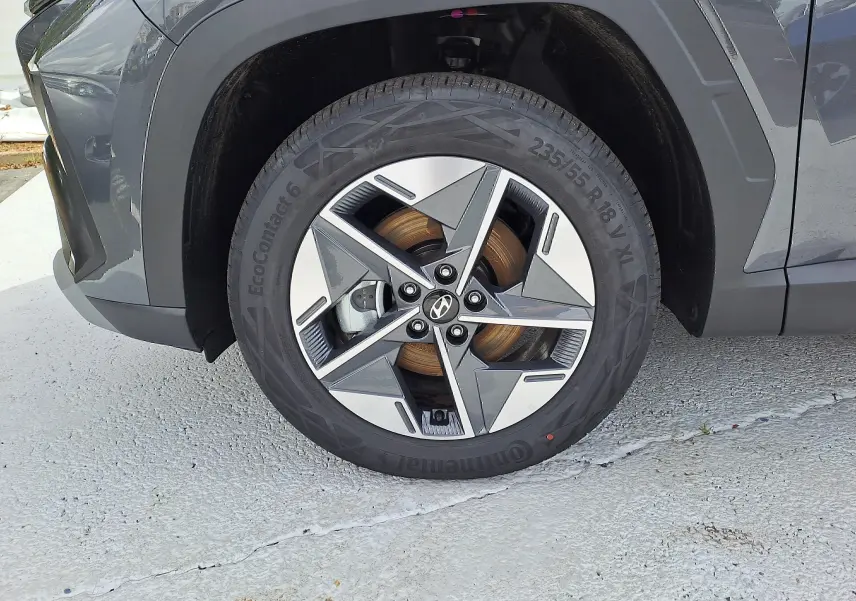 Gros plan sur la roue avant gauche du Hyundai Tucson 2025 gris Ecotronic avec jante alliage à design géométrique.