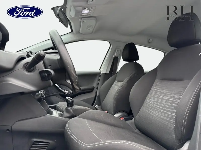 Vue intérieure côté gauche de la Peugeot 208 1.4 HDi Access 2013 avec sièges tissu gris et boîte manuelle