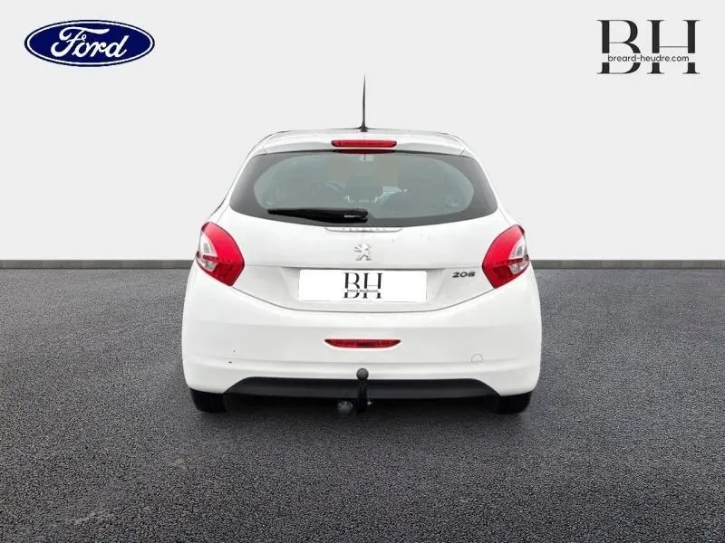Vue arrière d'une Peugeot 208 blanche Banquise de 2013 avec attelage et feux arrière rouges visibles.