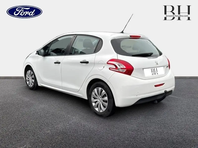 Peugeot 208 blanc banquise vue 3/4 arrière droit, compacte cinq portes avec feux arrière distinctifs rouges.