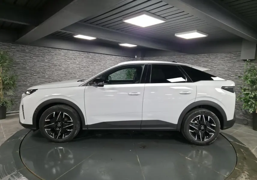 Peugeot 3008 blanc vue de profil côté gauche, jantes alliage noires et toit noir contrasté dans un showroom.