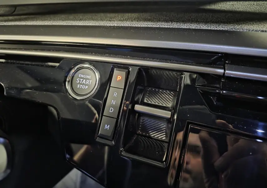 Gros plan sur la console centrale noire laquée du Peugeot 3008 blanc, avec bouton start/stop et sélecteur de boîte auto.