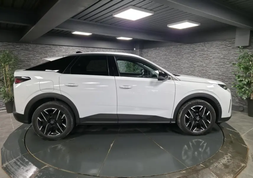 Peugeot 3008 blanc en vue profil côté gauche, avec jantes alliage noires et protections noires sur passages de roues.