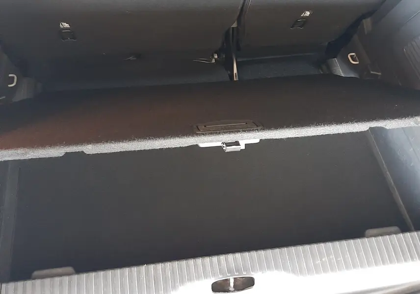 Coffre ouvert vu de dessus du Citroën C3 Aircross sable métal, montrant le compartiment de rangement sous plancher.