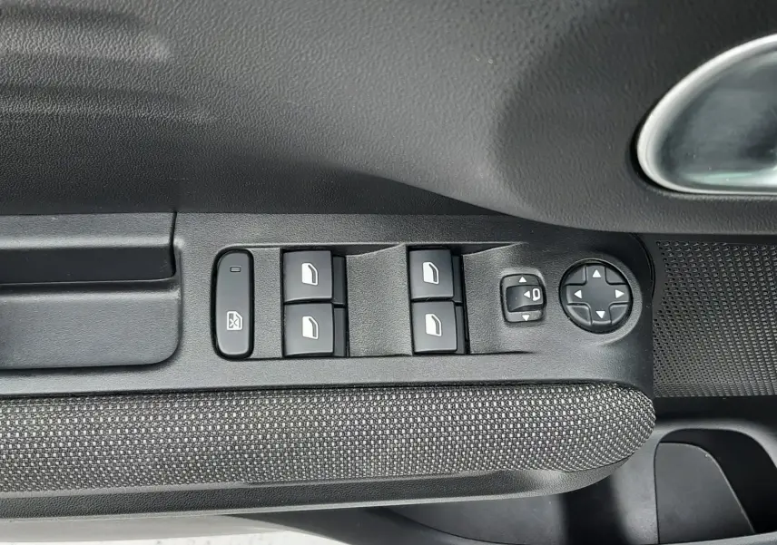 Gros plan sur les commandes des vitres électriques et réglages des rétroviseurs côté conducteur du Citroën C3 Aircross sable métal.